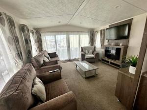 sala de estar con sofá y TV en 6 berth luxury caravan, Lyons Winkups Holiday Park, en Kinmel Bay