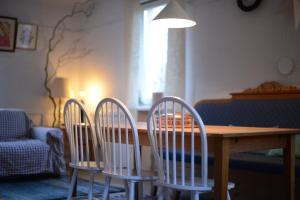 three chairs around a wooden table in a living room at Odpocznij in Dąbrówka