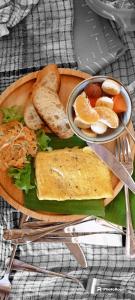 a plate of food with toast bread and fruit at Harry's Ocean House Watukarung Homestay in Kalak