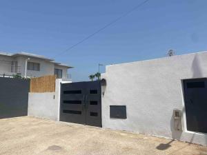 ein weißes Gebäude mit einem Tor und einer Garage in der Unterkunft Étage de villa entier et indépendant C in Rabat