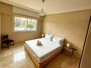 um quarto com uma grande cama branca e uma janela em Étage de villa entier et indépendant C em Rabat