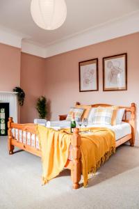 a bedroom with a large bed with a yellow blanket at STUNNING 5 bed House in Clapham - FREE WIFI! in London