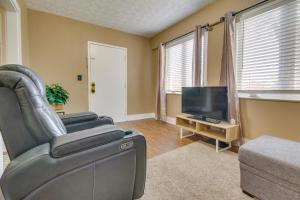 a living room with a leather chair and a flat screen tv at Convenient Dayton Vacation Rental Near Downtown! in Dayton