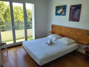 sypialnia z łóżkiem oraz balkon z przesuwnymi szklanymi drzwiami w obiekcie LE CENTRAL w Montpellier