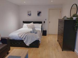 a bedroom with a bed with a dresser and a mirror at The Bow Hub in London