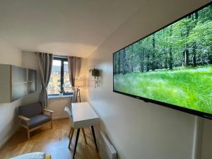 sala de estar con TV de pantalla plana grande en la pared en The Bow Hub en Londres