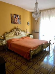 1 dormitorio con 1 cama con colcha de color naranja en Appartamento nel cuore della Basilicata, en Ruvo del Monte