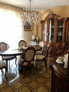 comedor con mesa, sillas y lámpara de araña en Appartamento nel cuore della Basilicata, en Ruvo del Monte
