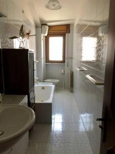 y baño con 2 aseos, lavamanos y bañera. en Appartamento nel cuore della Basilicata, en Ruvo del Monte