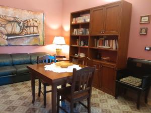 ein Wohnzimmer mit einem Tisch und einem Sofa in der Unterkunft Casa Castelli Appartamento vacanza in Bagheria