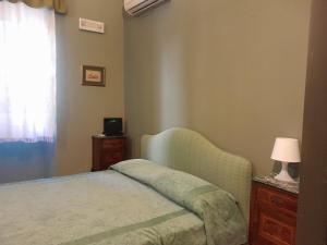 a bedroom with a bed and a lamp and a window at Casa Castelli Appartamento vacanza in Bagheria