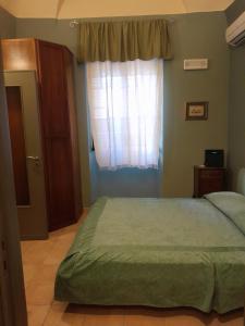 Schlafzimmer mit einem Bett und einem Fenster in der Unterkunft Casa Castelli Appartamento vacanza in Bagheria