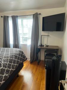 Dormitorio con cama, escritorio y TV en Debdorkdave Hospitality Services J, en Arlington