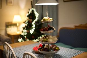 a table with three tiers of fruit on a table with a christmas tree at Odpocznij in Dąbrówka