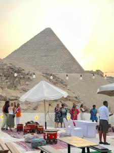 un grupo de personas parados frente a una pirámide en Villa Khufu Pyramids Inn en El Cairo