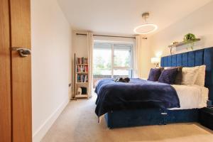 a bedroom with a blue bed and a window at Luxurious 1 Bedroom West Bridgford Apartment in Nottingham