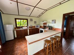 a kitchen with a counter and stools in it at Bambuda Castle in Boquete