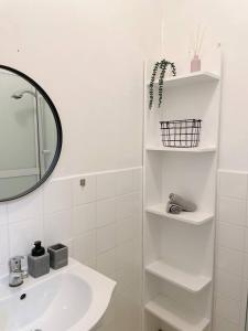 a white bathroom with a sink and a mirror at AR Comfort House in Košice