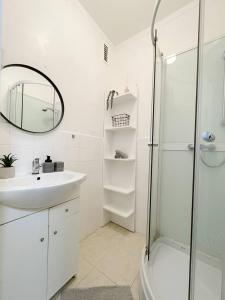 a white bathroom with a sink and a shower at AR Comfort House in Košice