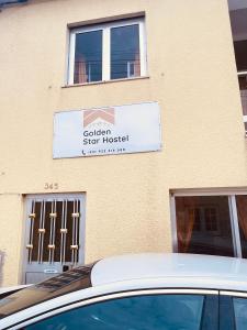 a car parked in front of a sign on a building at HOSTEL GOLDEN STAR in Gião