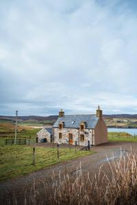 an old stone house in the middle of a field at Croft House, Armadale Bay in Armadale