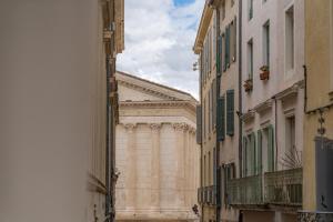 un gran edificio en medio de una calle en Loft calme à la Maison Carrée - Une Nuit à Nîmes, en Nimes