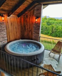 a hot tub on a patio with a wooden wall at Vikendica OM relax in Prijedor