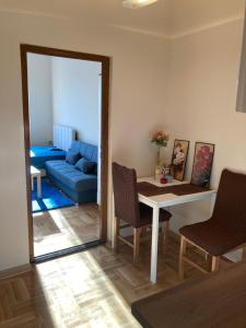 a living room with a table and a blue couch at Luks MM 4 in Pančevo