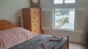 a bedroom with a bed with a dresser and a window at Beautiful Victorian Home in Plymouth