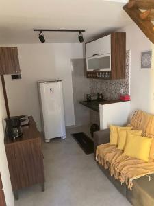 a living room with a couch and a refrigerator at Chalés D'Lis in Lençóis