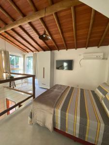 ein Schlafzimmer mit einem Bett und einem Tisch in einem Zimmer in der Unterkunft Chalés D'Lis in Lençóis