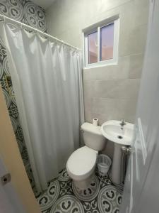 a bathroom with a toilet and a sink at Hotel AquaRoma in Higuey