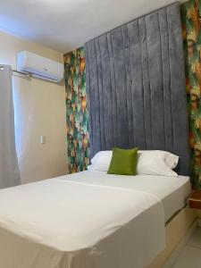 a bedroom with a large white bed with a gray headboard at Hotel AquaRoma in Higuey
