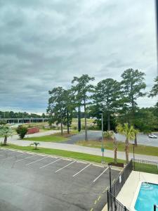 コロンビアにあるLa Quinta Inn by Wyndham Columbia NE Fort Jacksonのスイミングプールと木々のある駐車場