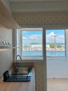 a kitchen with a sink and two windows with a view at Airiños da ría in Pontevedra
