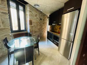 a kitchen with a table and a stainless steel refrigerator at Cathedral Dreams in Girona