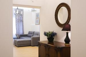 ein Wohnzimmer mit einem Sofa und einem Spiegel in der Unterkunft Audrey apartment Belgrade in Belgrad