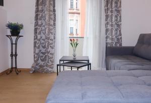 ein Wohnzimmer mit einem Sofa, einem Tisch und einem Fenster in der Unterkunft Audrey apartment Belgrade in Belgrad