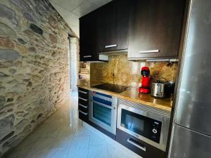 a kitchen with a stove and a stone wall at Cathedral Dreams in Girona +4 photos