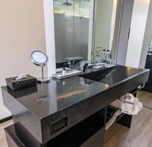 a bathroom with a black counter with a mirror at GHL Collection 93 in Bogotá