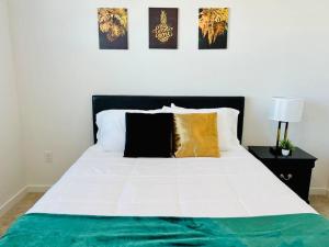 a bedroom with a white bed with gold and black pillows at Charming Home: 2BD/2BA in Kyle, TX! in Kyle