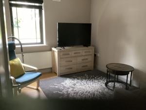 a living room with a tv and a chair and a table at Room to rent in Mullingar