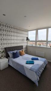 a bedroom with a large bed with blue pillows at 1 bedroom city centre apartment in Birmingham