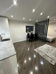 a kitchen and living room with a table and a bed at Studio T in Dagenham