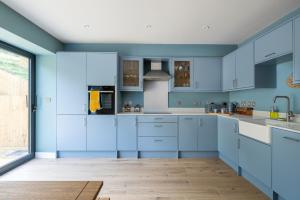 a blue kitchen with white cabinets and blue walls at H2-Roof Top-3 Bedrooms-2BA-Free Parking-Sleeps 6 