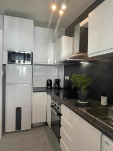 uma cozinha com armários brancos e um lavatório em Apartamento Flamingo Gran Alacant em Santa Pola