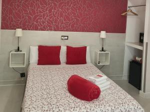 1 dormitorio con cama con almohadas rojas y almohada roja en Hostal Inn Madrid, en Madrid