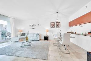 a living room with white walls and a table and chairs at Modern 1 Bed in the Heart of Brickell With Free Parking in Miami