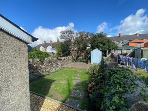 a backyard with a stone wall and a yard at Cardiff - Home from Home in Cardiff