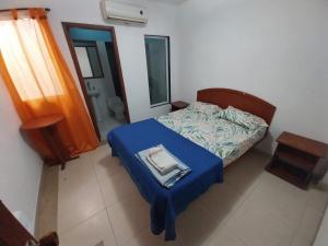 a small bedroom with a bed with a blue blanket at Hotel Vip Comfort Santa Marta in Santa Marta